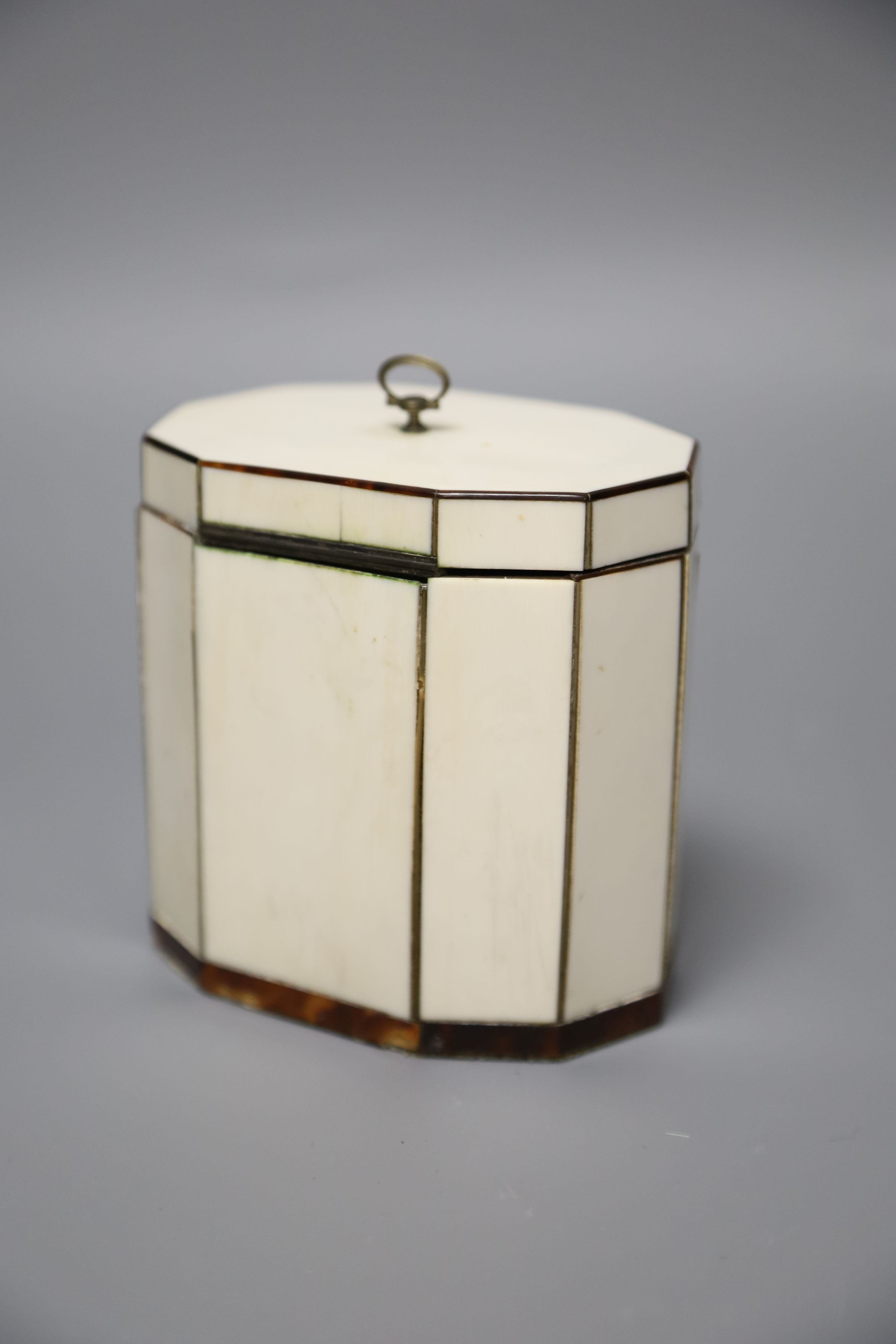 A George III octagonal ivory and tortoiseshell veneered tea caddy, height 10cm